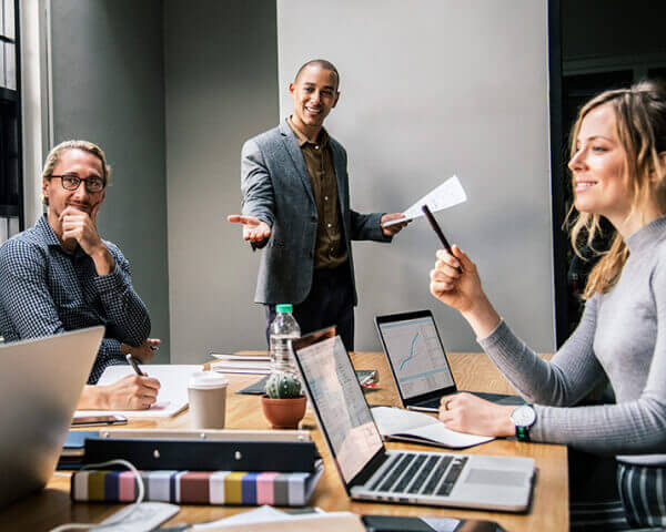 Image of professionals collaborating on a project, highlighting TensorForge's teamwork approach to delivering small business AI help and tech solutions.